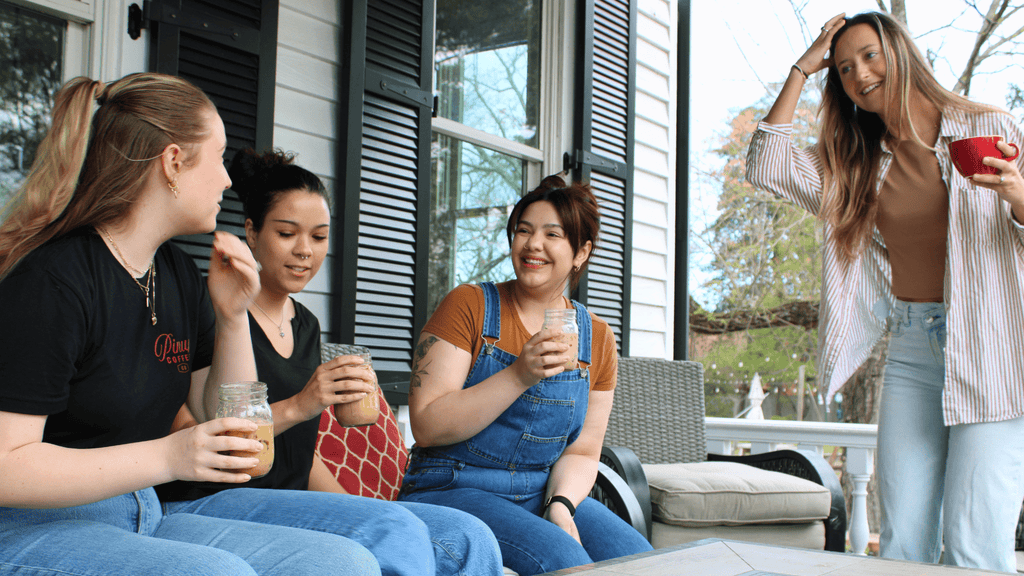 A group having iced coffee on the porch