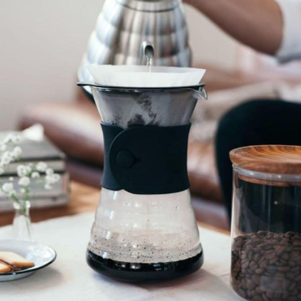 Pouring water over coffee in the dripper of Hario V60 coffee decanter