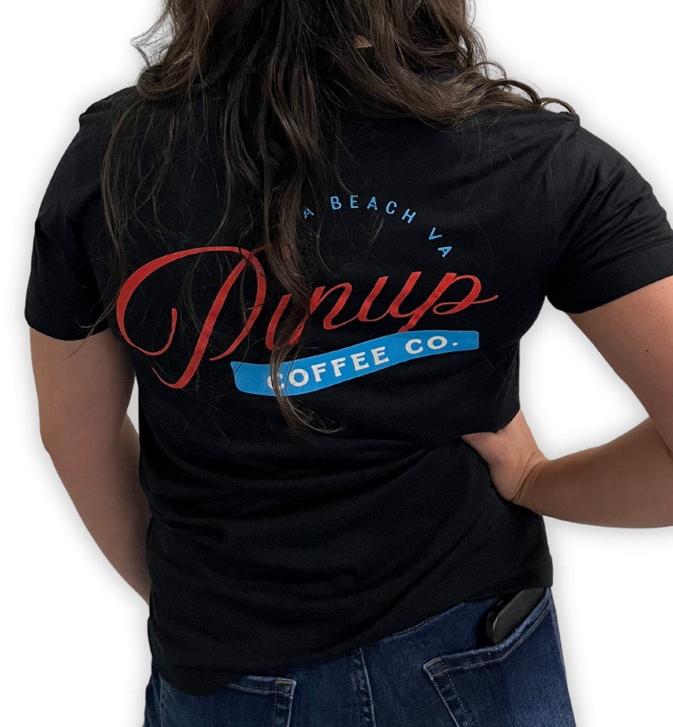 Rear view of a woman wearing a black t-shirt with the Pinup Coffee Co logo